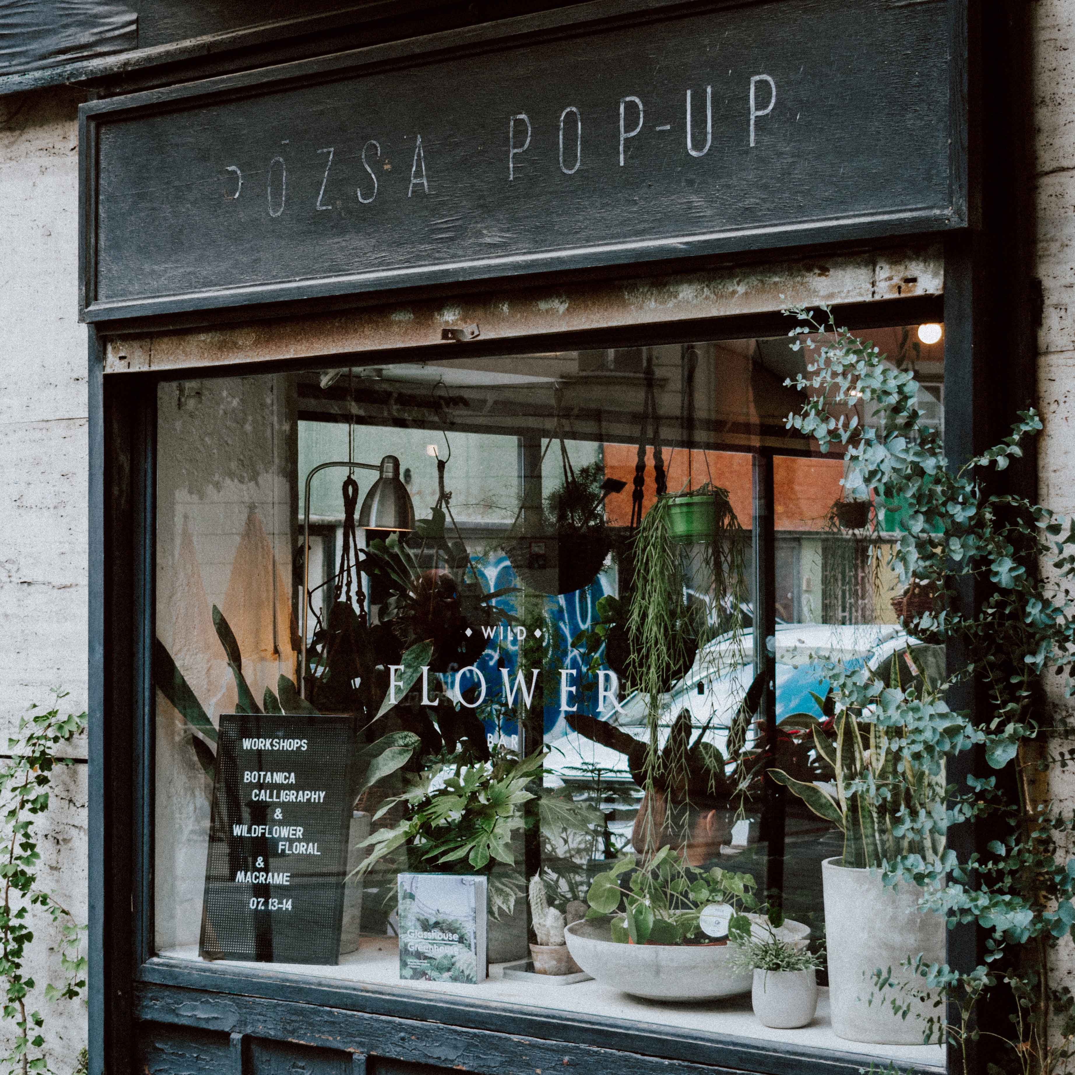 picture of a flower shop with flowers in front